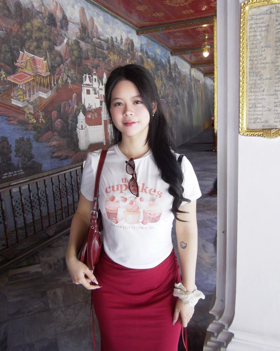 Helena Dang standing in a temple hallway with painted murals